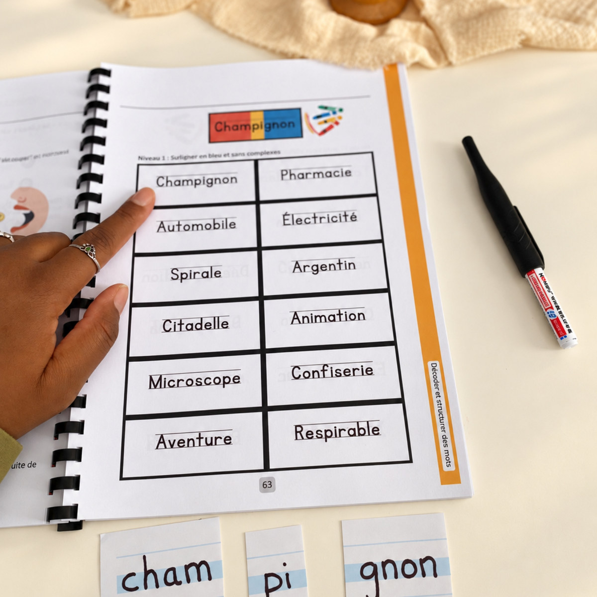 Le mot champignon découpé en syllabes, cham, pi, gnon, sous la page 63 du cahier