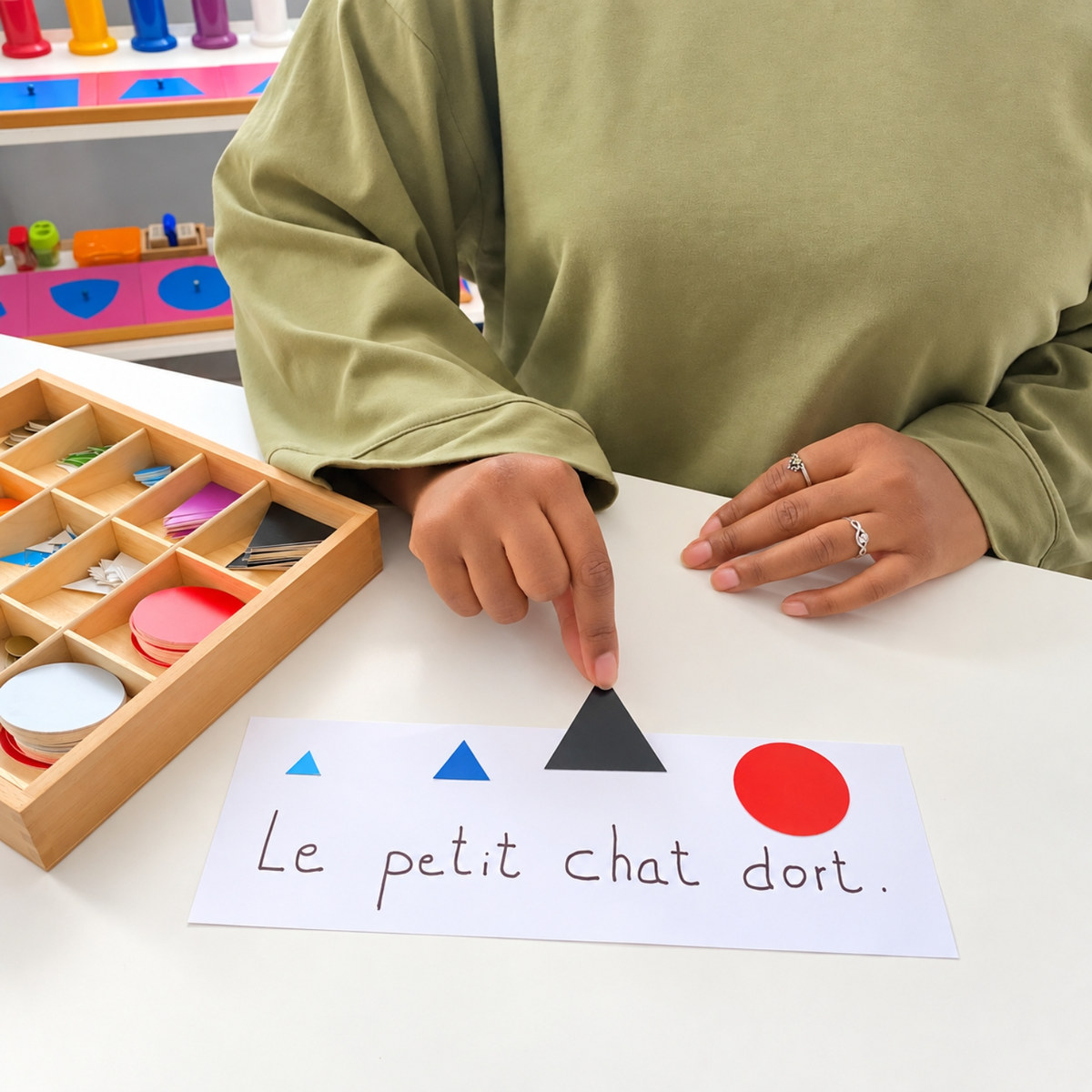 Alima pose le symbole du nom au-dessus de la phrase Le petit chat dort