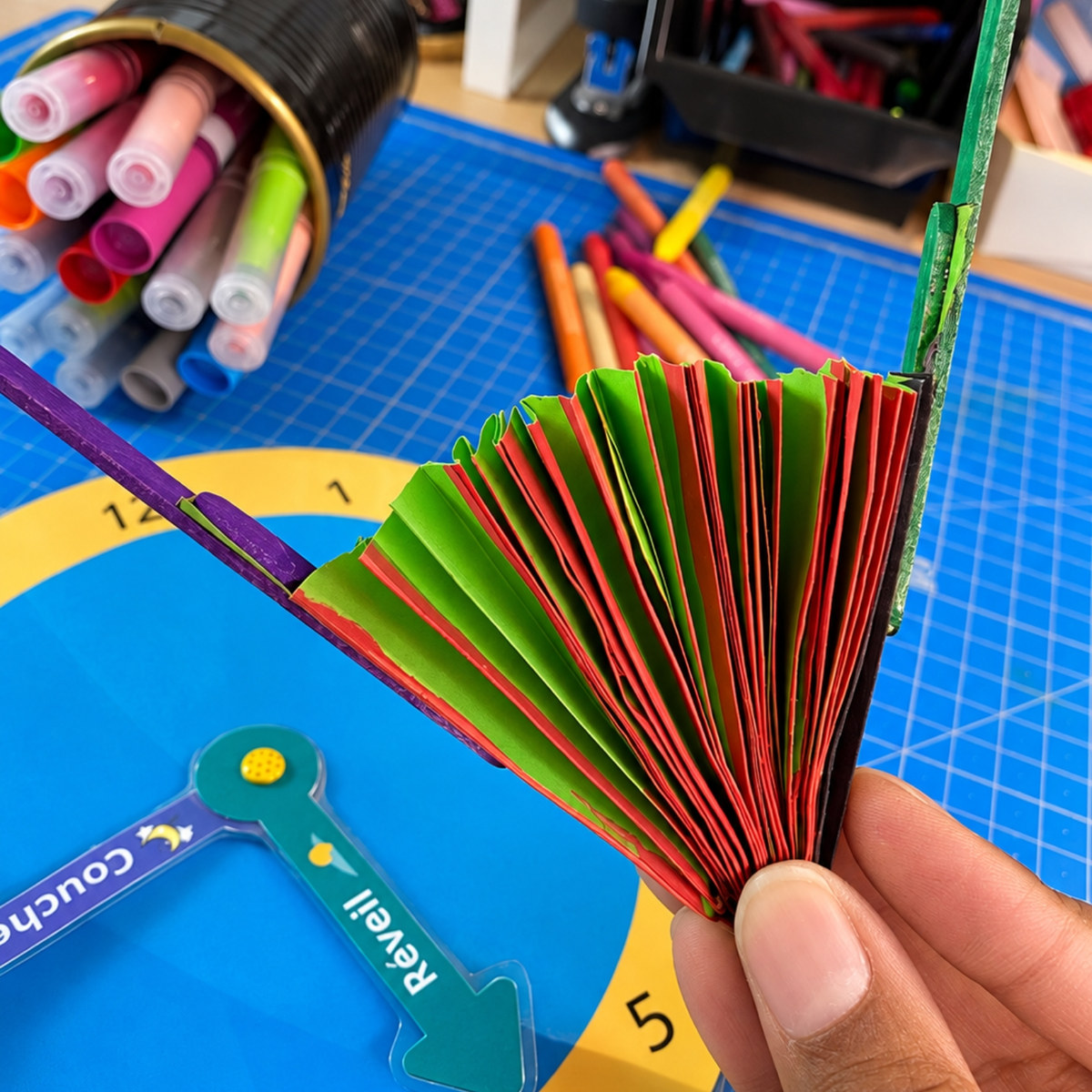Le matériel de l'atelier : l'horloge Coucher et Réveil, l'éventail en papier et les feutres
